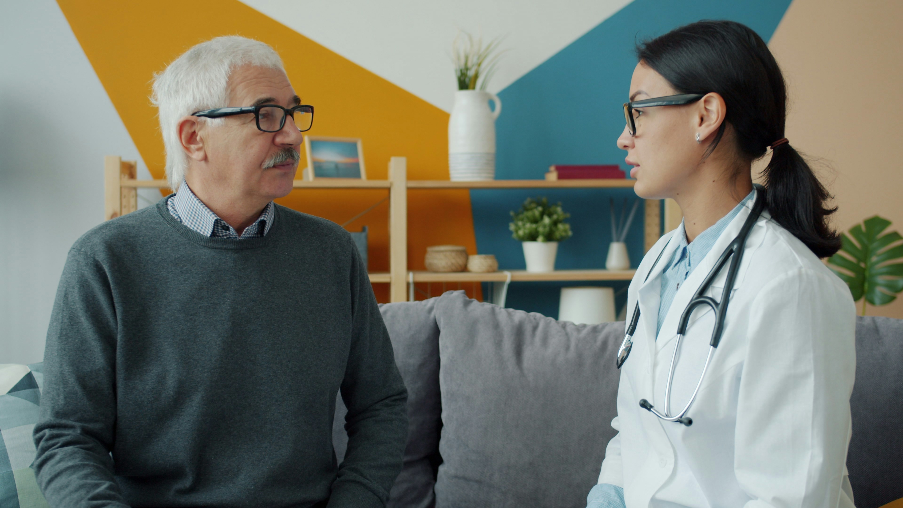 An older man in conversation with his doctor in a home setting